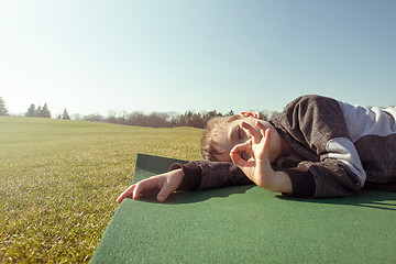 Image showing Boy sleep outdoors in the autumn park