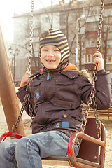 Image showing Boy swinging on a swing