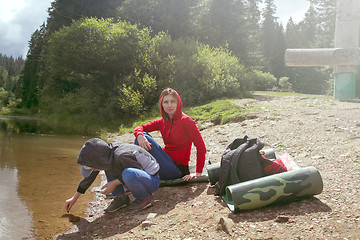 Image showing Mother and son is sitting by the lake