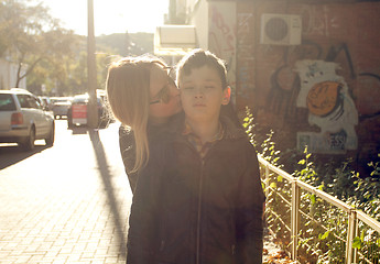 Image showing Mother is kissing her son on the cheek