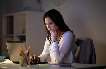 Image showing businesswoman with laptop at night office