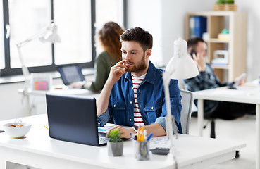 Image showing creative man with laptop working at office