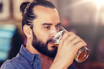 Image showing happy man drinking beer at bar or pub