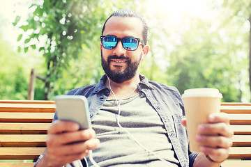 Image showing man with earphones and smartphone drinking coffee