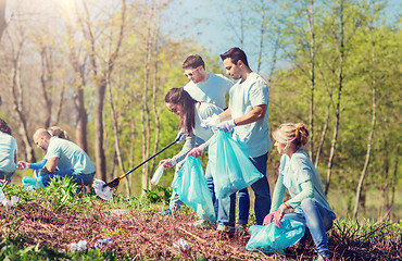 Image showing volunteers with garbage bags cleaning park area