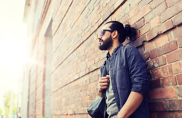 Image showing man with backpack standing at city street wall