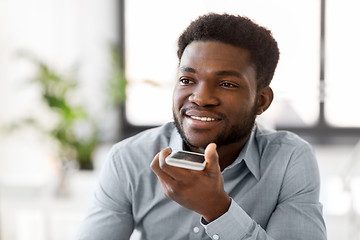 Image showing businessman records voice by smartphone at office