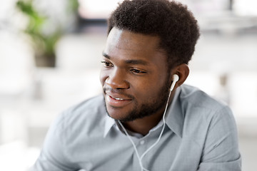 Image showing man with earphones listening to music at office