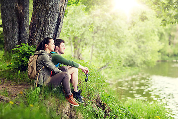 Image showing smiling couple with backpacks in nature