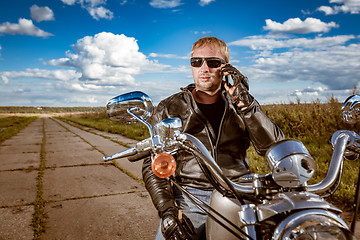 Image showing Biker talking on a smartphone.