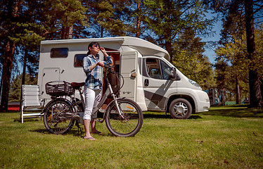 Image showing Woman on electric bike resting at the campsite VR Caravan car Va