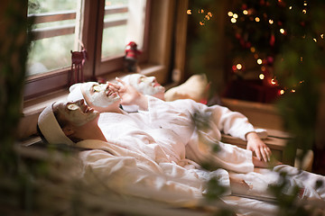 Image showing women is getting facial clay mask at spa