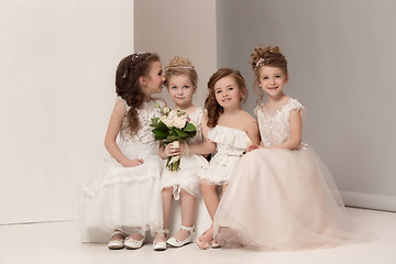 Image showing Little pretty girls with flowers dressed in wedding dresses