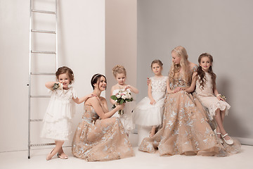 Image showing Little pretty girls with flowers dressed in wedding dresses