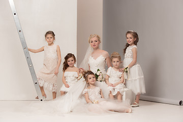 Image showing Little pretty girls with flowers dressed in wedding dresses