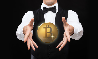 Image showing close up of magician with bitcoin over black