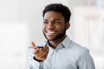 Image showing businessman records voice by smartphone at office