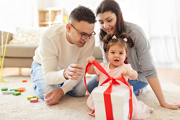 Image showing baby girl with birthday gift and parents at home