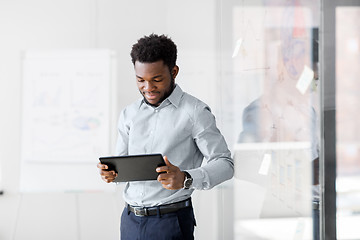 Image showing smiling businessman with tablet pc at office