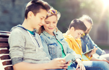 Image showing happy teenage friends with tablet pc outdoors