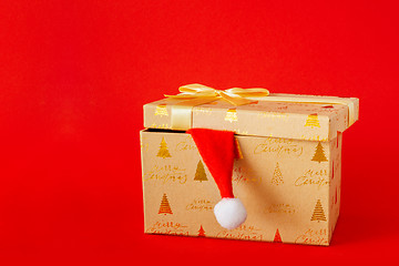 Image showing Christmas gift box with Santa Claus hat on red background