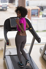 Image showing afro american woman running on a treadmill