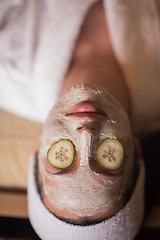 Image showing woman is getting facial clay mask at spa