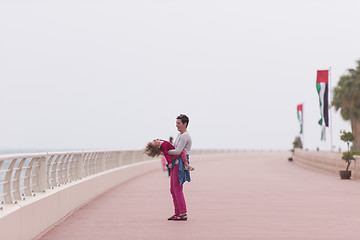 Image showing mother and cute little girl on the promenade by the sea