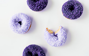 Image showing close up of purple glazed donuts pile over white