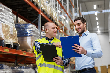 Image showing worker and businessman with clipboard at warehouse