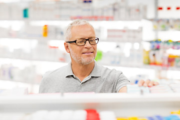 Image showing senior male customer with drug at pharmacy