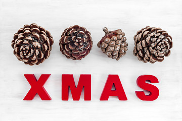 Image showing Pine tree cones and the word Xmas written in red letters