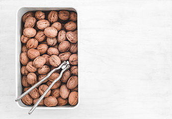 Image showing Walnuts and nutcracker in a box on white background