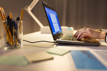 Image showing businesswoman with laptop working at night office