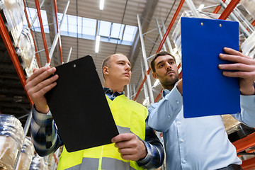 Image showing worker and businessman with clipboard at warehouse