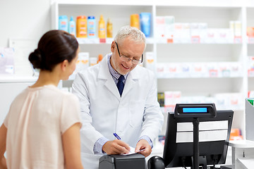 Image showing senior apothecary with prescription at pharmacy