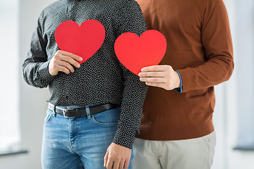 Image showing close up of happy male couple holding red hearts