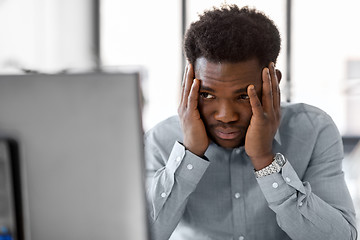 Image showing stressed businessman with computer at office