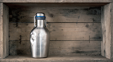 Image showing old dented metal bottle on wooden background