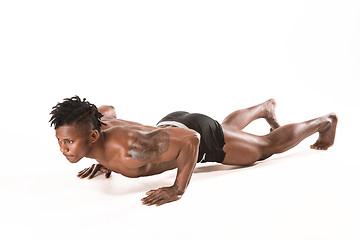 Image showing Muscular young man doing press-ups