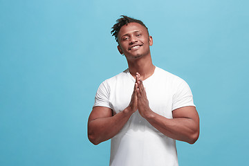 Image showing The happy business afro-american man standing and smiling against blue background.