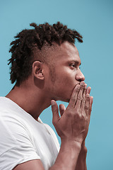 Image showing Portrait of attractive Afro-American man with air kiss isolated over blue background