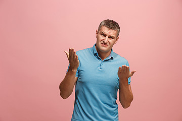 Image showing Beautiful male half-length portrait isolated on pink studio backgroud. The young emotional surprised man