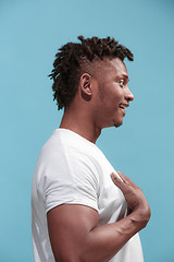 Image showing The surprised business Afro-American man standing and looking blue background. Profile view.