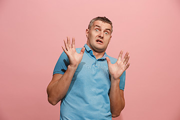 Image showing Portrait of the scared man on pink