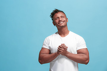 Image showing The happy business afro-american man standing and smiling against blue background.