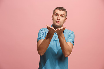 Image showing Portrait of attractive man with kiss isolated over pink background