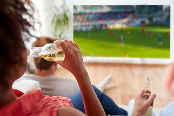 Image showing woman drinking beer and watching soccer game