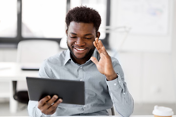 Image showing businessman having video chat on tablet at office