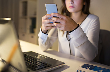 Image showing businesswoman with smartphone and laptop at office